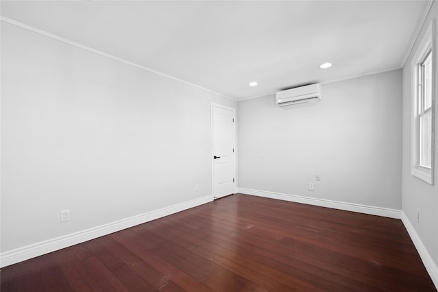 unfurnished room with an AC wall unit, dark hardwood / wood-style flooring, and ornamental molding