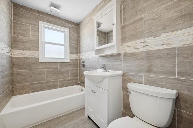 full bathroom featuring vanity, toilet, and tile walls