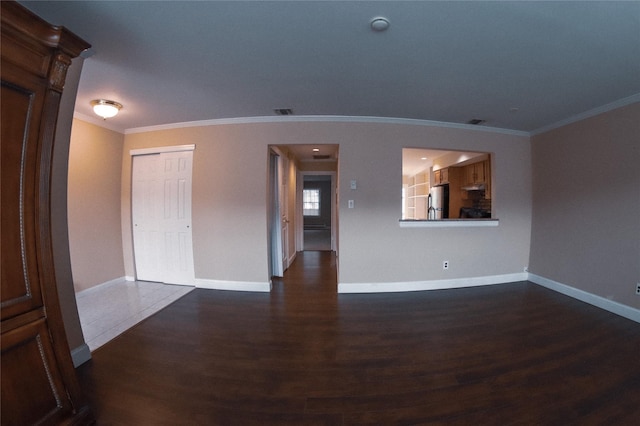 empty room with dark hardwood / wood-style flooring and ornamental molding