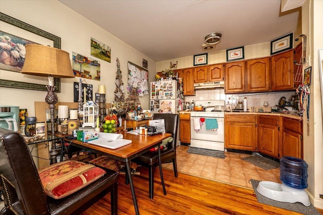 kitchen with decorative backsplash, light hardwood / wood-style floors, and white appliances