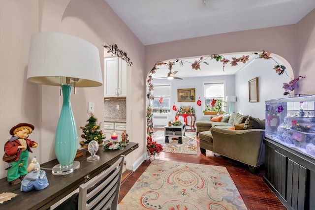 living area featuring ceiling fan and dark wood-type flooring