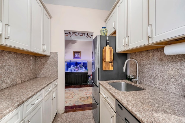 kitchen with white cabinets, sink, and light tile patterned floors