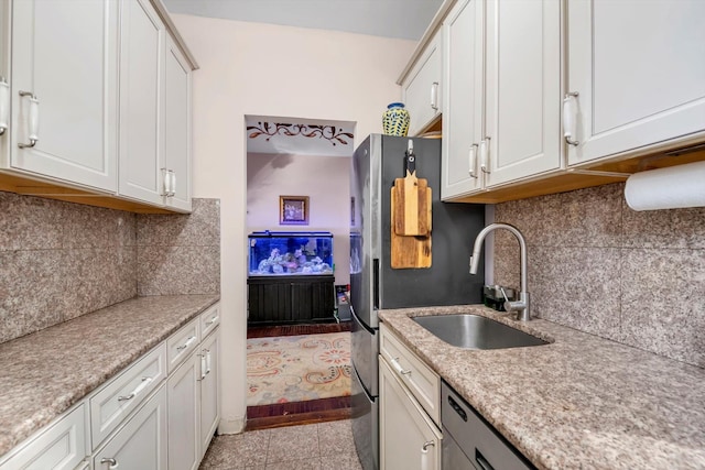 117-01 Park Ln S Unit B2L, Kew Gardens, NY 11415 - kitchen featuring light stone countertops, white cabinetry, a sink, and backsplash