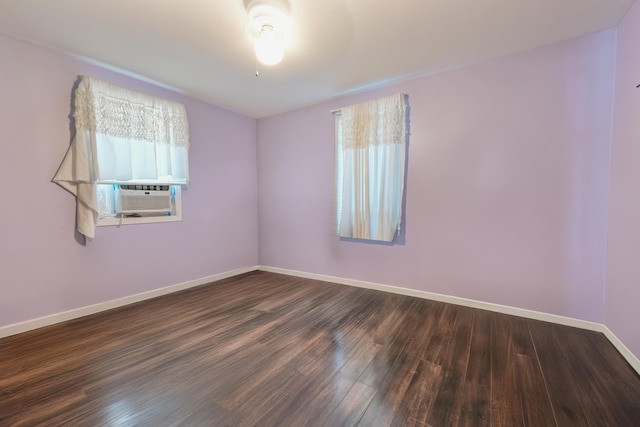 empty room with cooling unit and dark hardwood / wood-style flooring