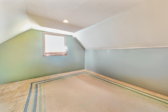 bonus room featuring parquet floors and vaulted ceiling