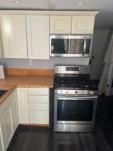 kitchen featuring white cabinets, appliances with stainless steel finishes, wooden counters, and dark wood finished floors