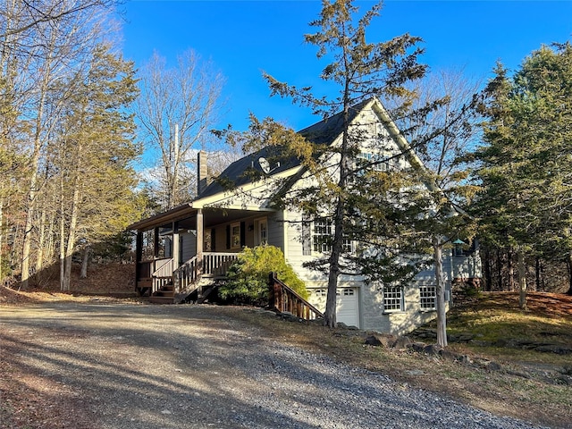 view of property exterior featuring a porch and a garage