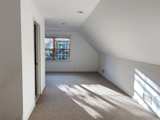 bonus room with lofted ceiling and carpet floors