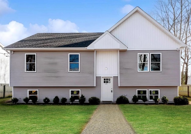 bi-level home featuring a front lawn and a shingled roof