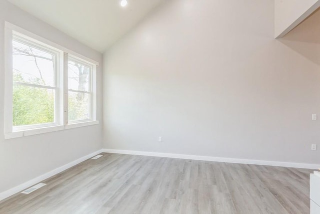 unfurnished room featuring light hardwood / wood-style floors and vaulted ceiling