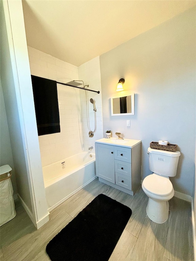 full bathroom featuring wood tiled floor, bathtub / shower combination, vanity, and toilet