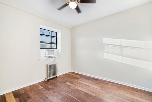 spare room with radiator, ceiling fan, cooling unit, and hardwood / wood-style flooring