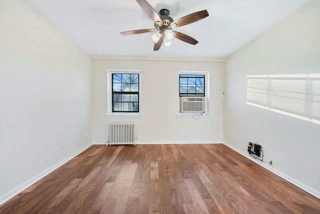 unfurnished room featuring hardwood / wood-style flooring, radiator, cooling unit, and ceiling fan