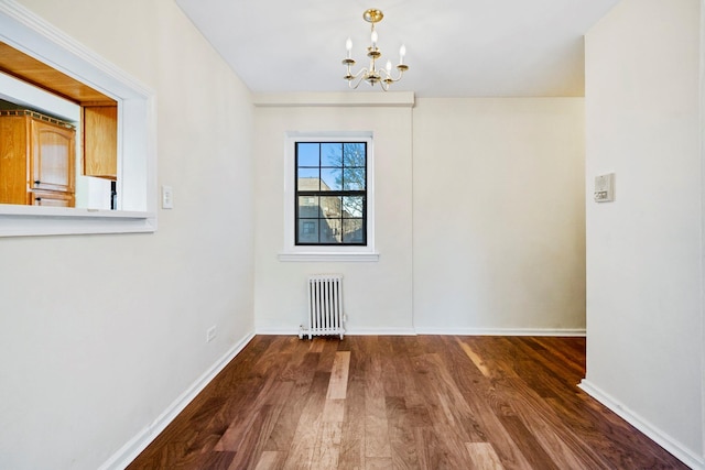 unfurnished dining area featuring radiator heating unit, hardwood / wood-style flooring, and a notable chandelier