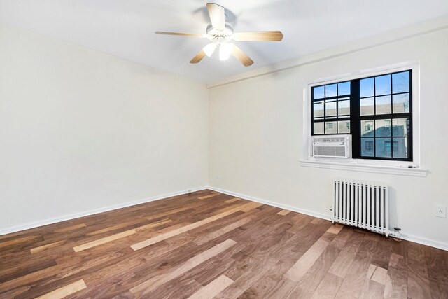 empty room featuring radiator, ornamental molding, cooling unit, ceiling fan, and hardwood / wood-style floors