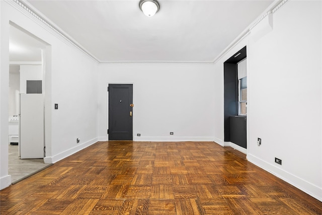 empty room featuring dark parquet flooring and crown molding