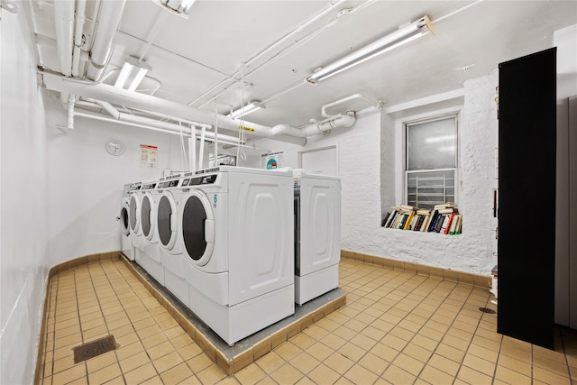 laundry area with separate washer and dryer and light tile patterned floors