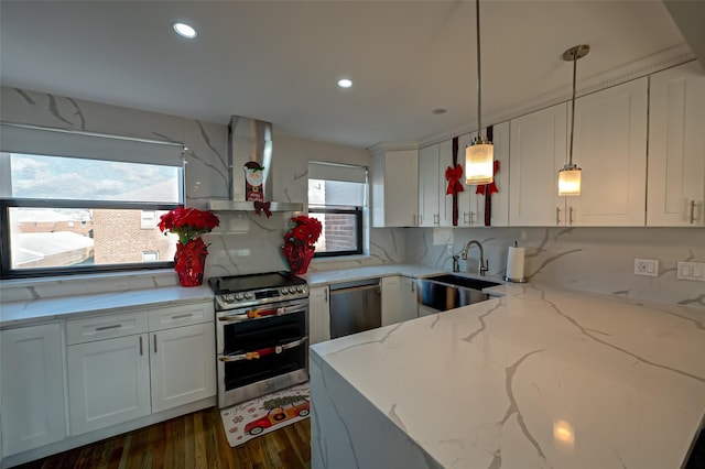 kitchen with sink, hanging light fixtures, light stone counters, ventilation hood, and appliances with stainless steel finishes