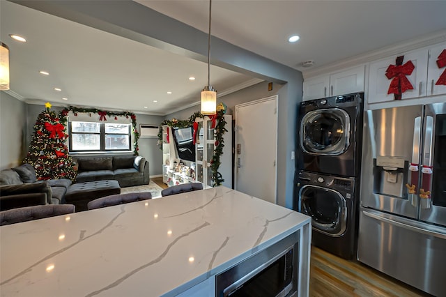 kitchen with light stone countertops, stacked washing maching and dryer, pendant lighting, stainless steel fridge with ice dispenser, and dark hardwood / wood-style floors