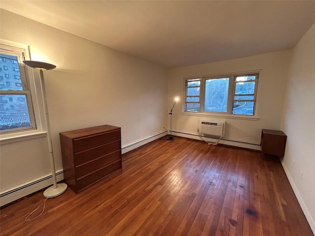 spare room with dark wood-type flooring, a baseboard radiator, and a wall mounted AC