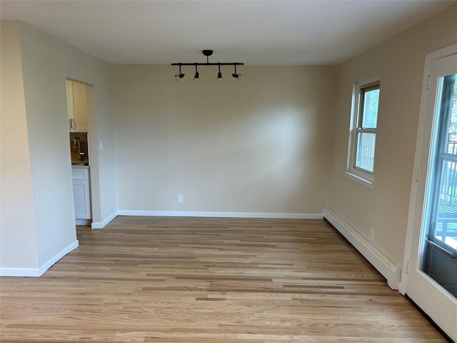 665 Pelham Rd Unit A15, New Rochelle, NY 10805 - unfurnished dining area with light wood-style flooring, healthy amount of natural light, a baseboard heating unit, and baseboards