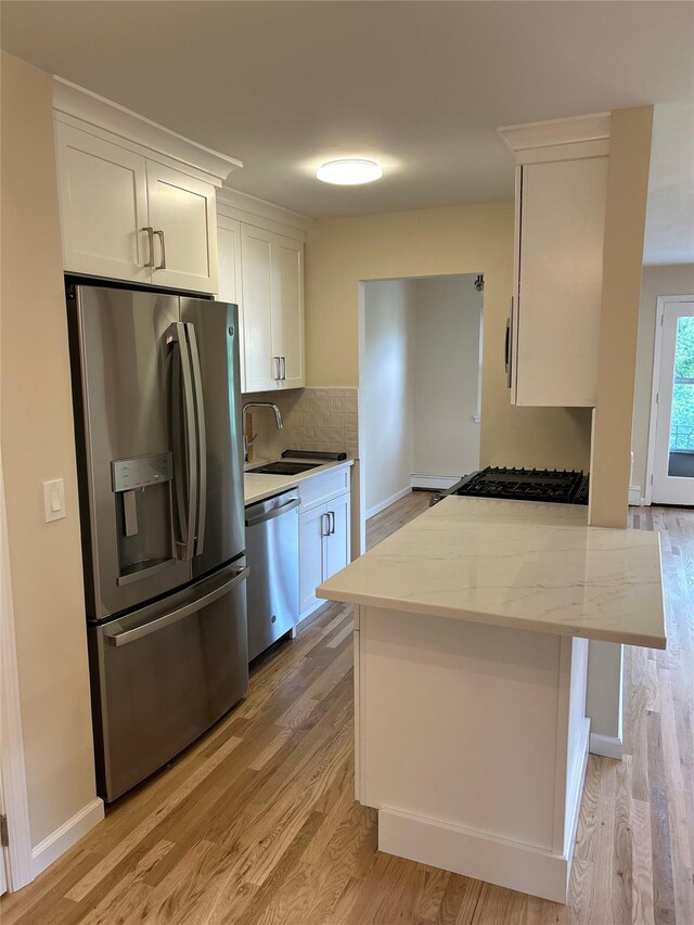 665 Pelham Rd Unit A15, New Rochelle, NY 10805 - kitchen featuring appliances with stainless steel finishes, light wood-style floors, white cabinets, tasteful backsplash, and a sink