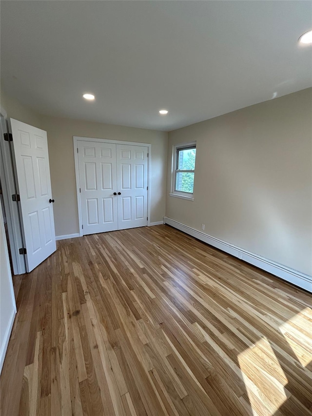 665 Pelham Rd Unit A15, New Rochelle, NY 10805 - unfurnished bedroom featuring wood finished floors, a baseboard radiator, a closet, recessed lighting, and baseboards