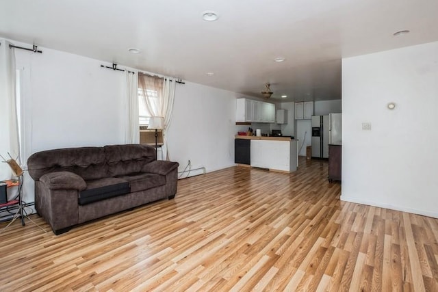 living room featuring light wood-type flooring and baseboard heating