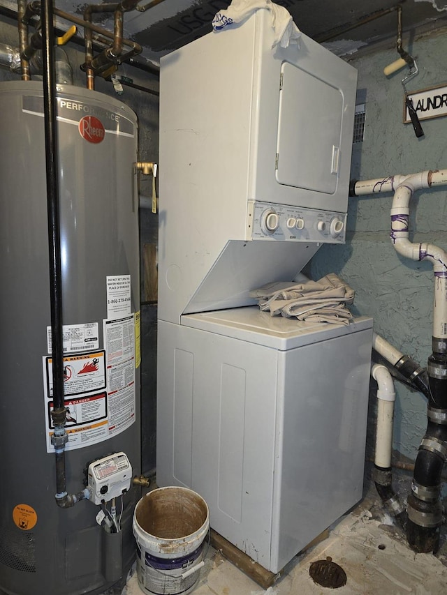 clothes washing area with gas water heater and stacked washer / drying machine