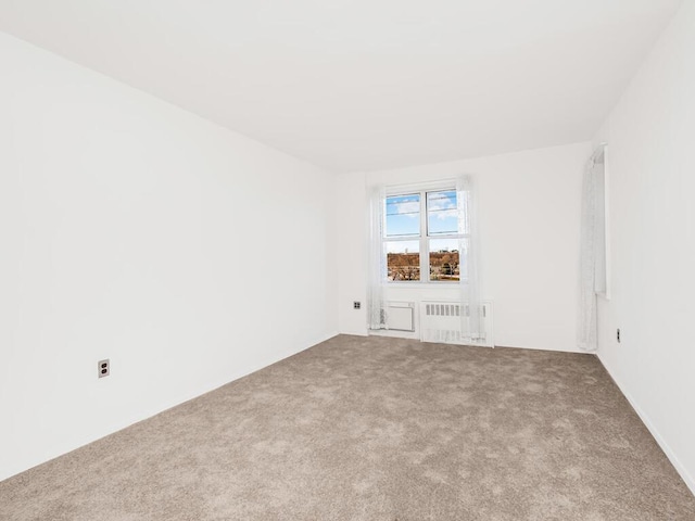 spare room with carpet floors and radiator