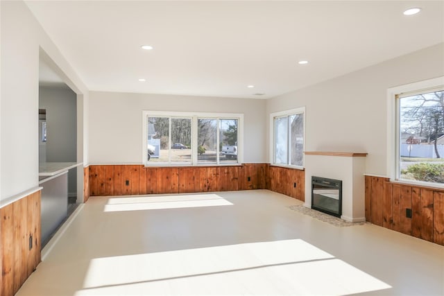 unfurnished living room with concrete floors and wooden walls