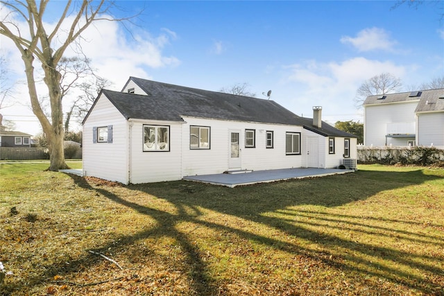 rear view of property featuring a lawn, central AC unit, and a patio area