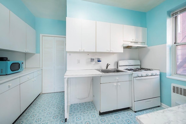 kitchen with white cabinets, sink, white appliances, and radiator heating unit