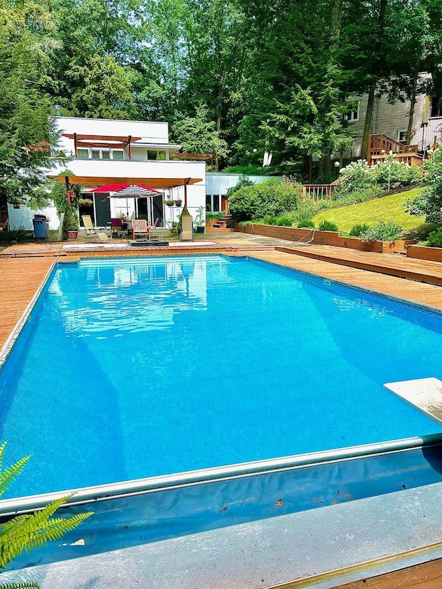 view of swimming pool featuring a diving board