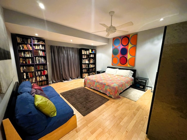 bedroom featuring ceiling fan, light hardwood / wood-style floors, and baseboard heating