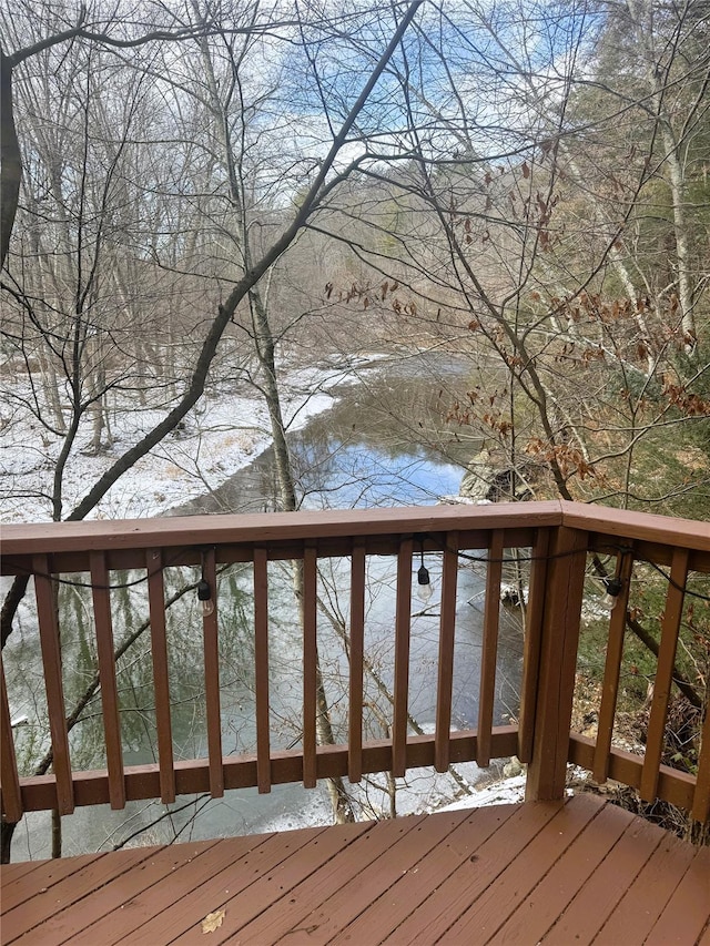 snow covered deck featuring a water view