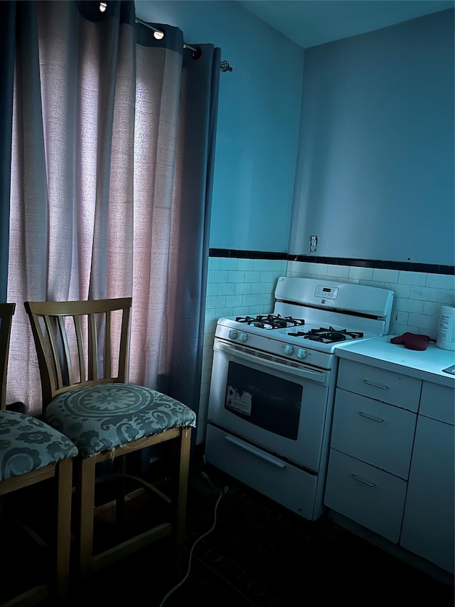 kitchen featuring tile walls and gas range gas stove