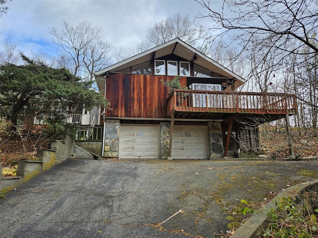 view of front facade featuring a garage and a wooden deck