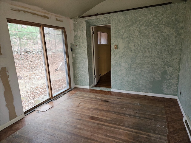 unfurnished room featuring vaulted ceiling and hardwood / wood-style flooring