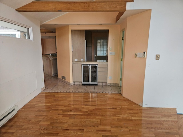 kitchen featuring wine cooler, light hardwood / wood-style flooring, beamed ceiling, and a baseboard radiator