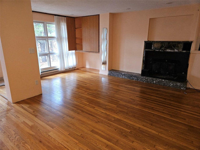 unfurnished living room with a textured ceiling and light hardwood / wood-style floors