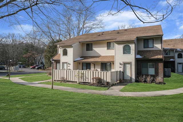 rear view of house featuring a lawn and central AC