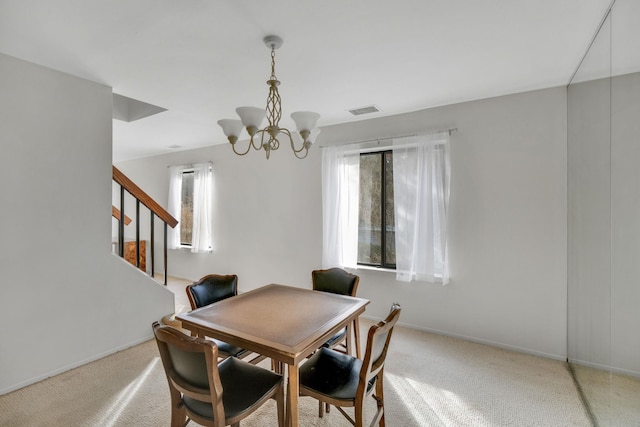 dining area featuring light carpet and an inviting chandelier