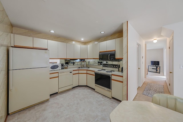 kitchen with sink, white cabinets, and white appliances