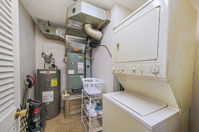 clothes washing area featuring stacked washer / dryer and water heater