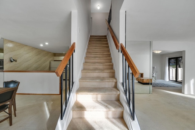 stairway featuring carpet flooring