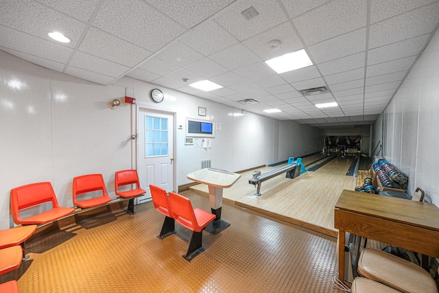 game room with a paneled ceiling and a bowling alley