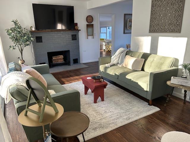 living room featuring a fireplace and dark wood-type flooring