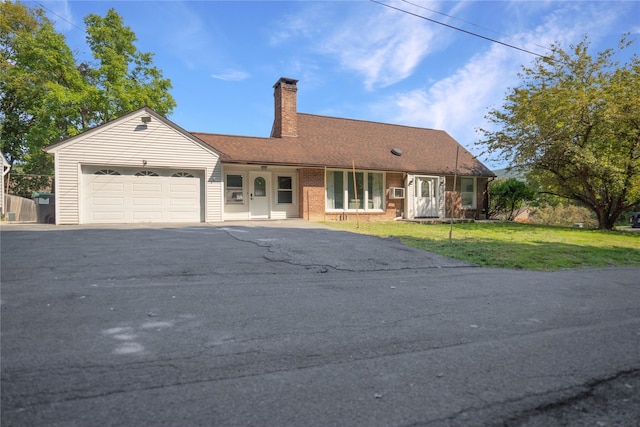 ranch-style home featuring a garage and a front lawn