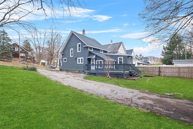 rear view of house featuring a yard and a wooden deck